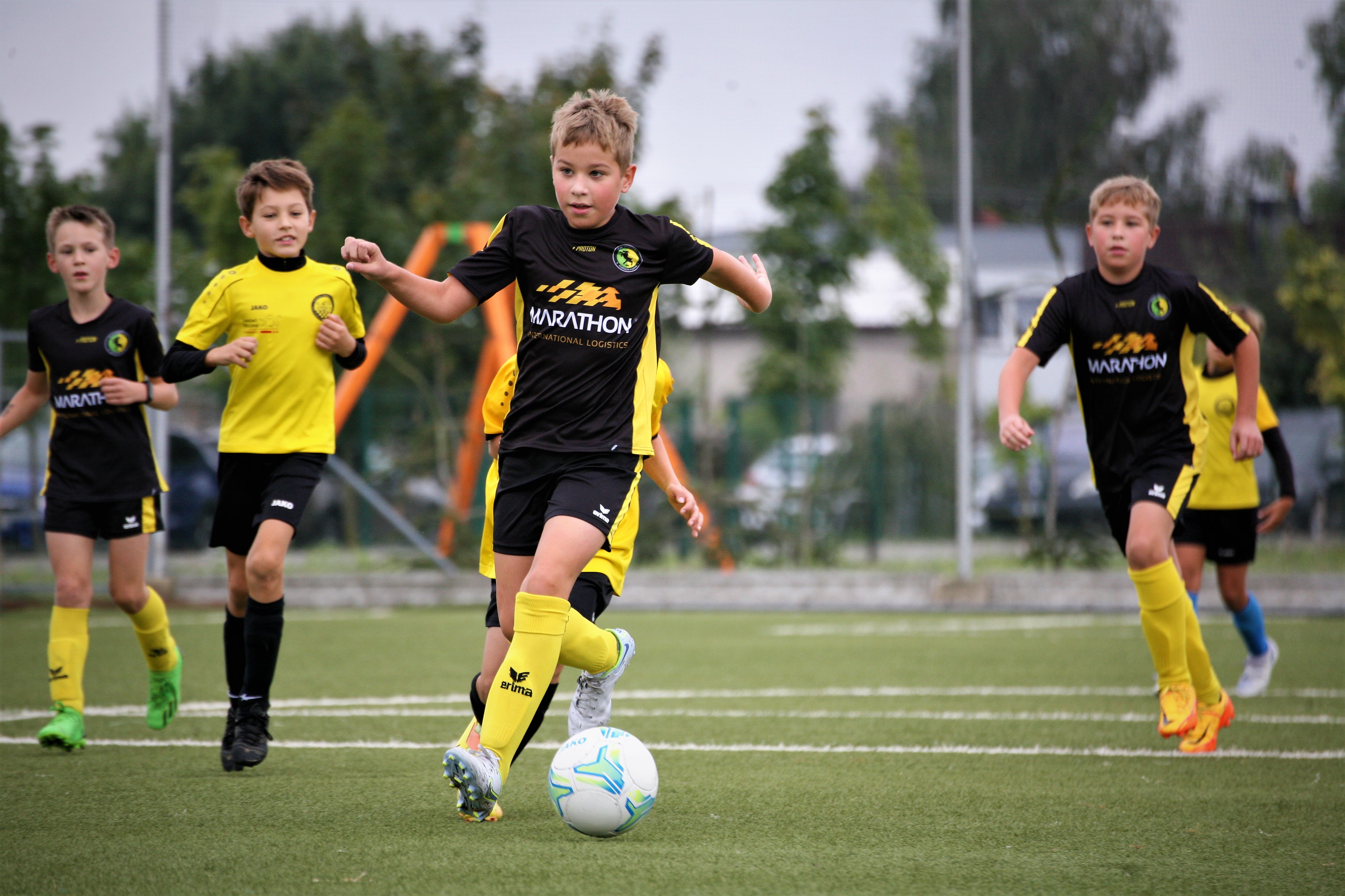 Chłopcy grają w piłkę na boisku Młodzieżowego Ośrodka Sportowego