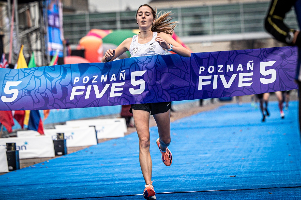 Zawodniczka przebiega przez wstęgę z napisem Poznań Five