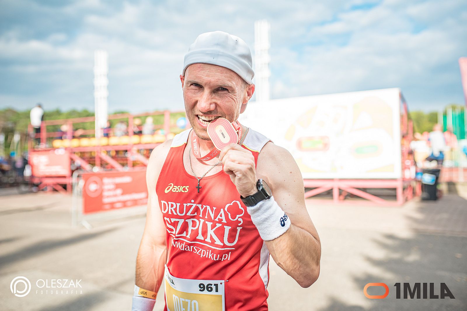 Jacek Mezo Mejer pozuje do zdjęcia trzymając medal w zębach