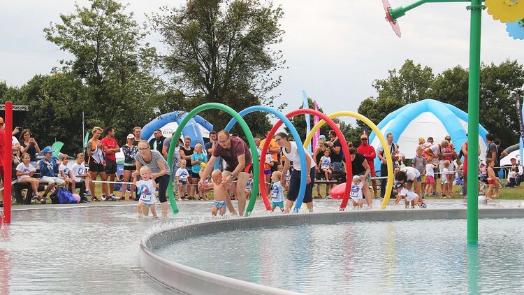 Dzieci z rodzicami w brodziku podczas zawodów triathlonowych na Chwiałce