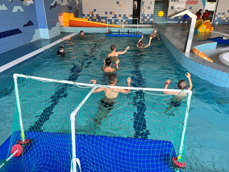 Dzieci grają w piłkę wodną w basenie
