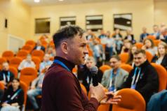 Prelegent w trakcie panelu dyskusyjnego z mikrofonem w ręce
