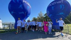 grupa osób ruszająca do biegu, z tyłu balony z napisem POZNAŃ